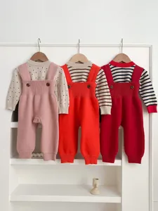 Detailed view of baby knit overalls set, infant long-sleeve romper with cute patterns.