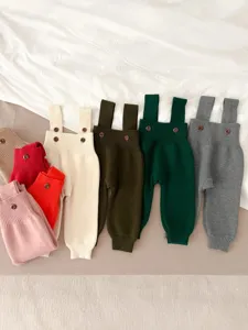 Baby knit strap pants detail showcasing soft rib texture and cute button design for infants.