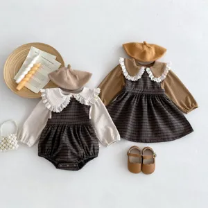 Baby plaid sister outfit detail showing romper, dress, beret, and matching shoes setup.