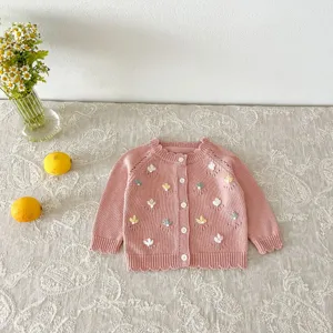 Baby girl cute pink knit cardigan sweater detail featuring floral embroidery and button design.