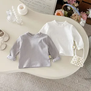 Detaillierte Nahaufnahme süßer gerippter Baumwoll-Langarm-T-Shirts für Kleinkinder in Grau und Weiß.