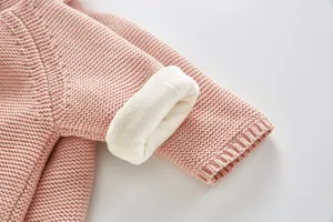 Close-up detail of baby pink knit cardigan featuring thick soft fleece lining, warm and cozy.