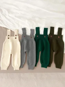 Detailed shot of baby knit suspender pants showing soft texture, delicate buttons and cute straps.
