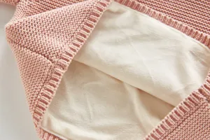 Detailed view of thick fleece lining inside the pink knit baby cardigan sweater, soft and warm fabric.