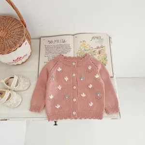 Infant baby girl knit cardigan detail, handmade floral embroidery, soft pink cotton yarn.