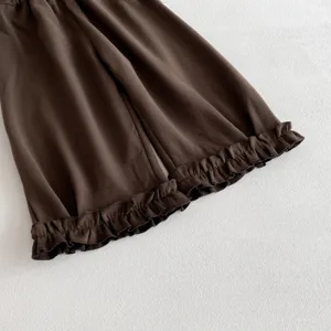 Détail de pantalon évasé pour enfants marron avec poignets à volants doux, vêtements de printemps.
