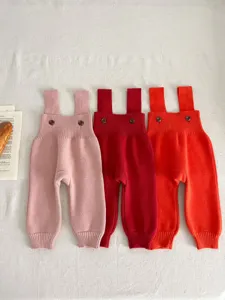 Infant knit overalls detail view, showing soft ribbed texture and cute button straps.
