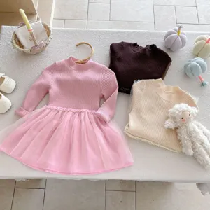 Scatto dettagliato di abito maglione in maglia per bambina e top con simpatici oggetti.