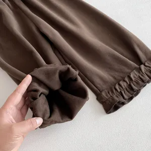 Gros plan sur les détails des pantalons unis pour enfants à volants, tissu doux et joli style.