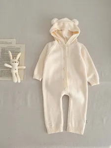 Vista plana detallada del pelele de punto beige para bebé con adorables orejas de oso y botones.