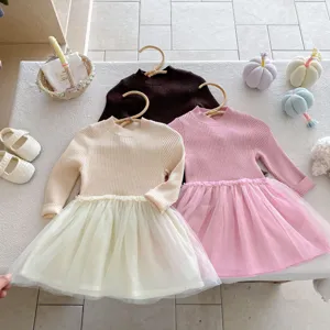 Dettaglio del vestito da bambina in maglia e tulle, maniche lunghe e gonna soffice.