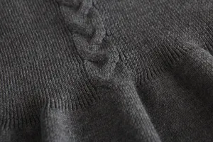 Dark grey knit fabric detail, classic cable knit texture, warm infant sweater texture close up.