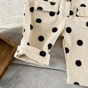 Nahaufnahme von beige Kleinkinderhose mit schwarzen Punkten und umgeschlagenen Bündchen.