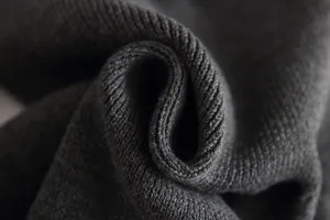 Detailed close-up view of dark grey infant knit sweater fabric showing soft texture.