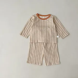 Detailed view of baby checkered long sleeve top and shorts set in brown and white gingham.