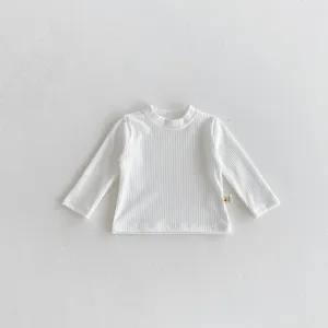 Detaillierte Nahaufnahme des weißen gerippten Baumwoll Langarmshirts für Babykleidung