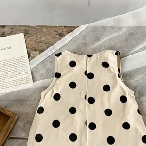 Baby Mädchen süßer ärmelloser Strampler Detail, klassischer schwarzer Pünktchen-Druck Stoff.