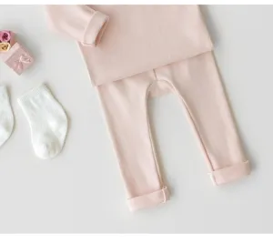 Dettaglio del set di leggings e top a maniche lunghe in cotone morbido per neonati rosa.