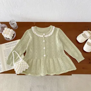 Detailed view of the baby knitted cardigan featuring delicate hollow-out pattern and white ruffle collar.
