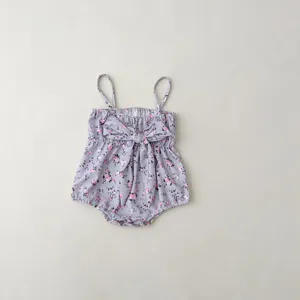 Infant baby floral swimsuit detail, cute purple romper with pink flowers and front bow tie.