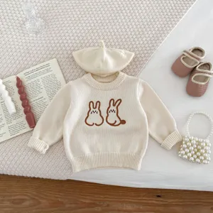 Detailed close up of cute baby knitted sweater featuring sweet rabbit embroidery design.