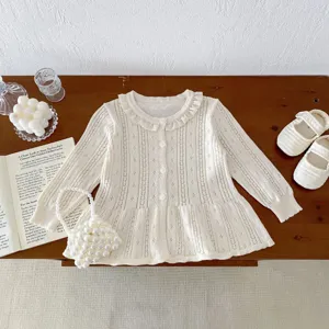 Detailed view of a cute ivory baby knitted cardigan with hollow-out design and pearl bag.
