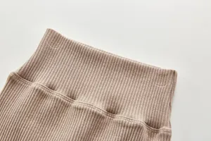 High-waist ribbed baby trousers detail shot, soft pure cotton fabric in solid khaki color.