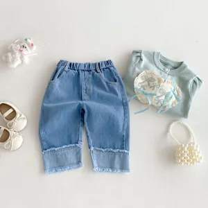 Detailed view of kids denim wide-leg pants and matching cardigan outfit set with cute accessories.