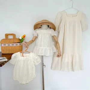 Detailed shot of Korean-style summer embroidered family matching dresses and cute baby rompers.