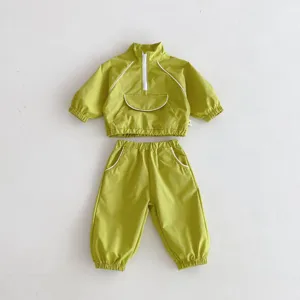 Vista detallada de chándal infantil con cuello alto, media cremallera y puños elásticos.
