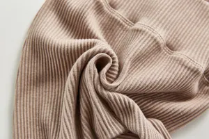 Detailed close-up of soft ribbed cotton baby pants fabric showing stretch and texture.