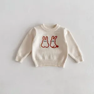 Close-up detail of cute rabbit embroidery on soft baby knit sweater, cozy texture.