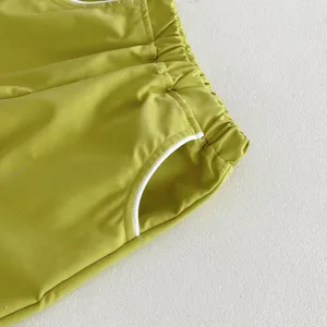 Vista detallada de pantalones deportivos infantiles con cintura elástica y bolsillo ribeteado.