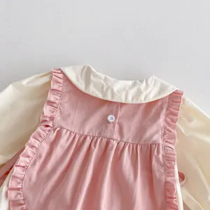 Nahaufnahme des niedlichen Babymädchens rosa Rüschenweste und Cremeshemd Set, weiche Baumwolle.