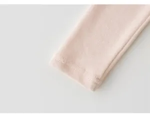 Vista dettagliata del polsino di leggings da neonato in cotone rosa con cuciture fini.