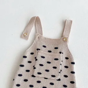 Baby knit overall detail view, cute polka dot pattern with shoulder straps and buttons.