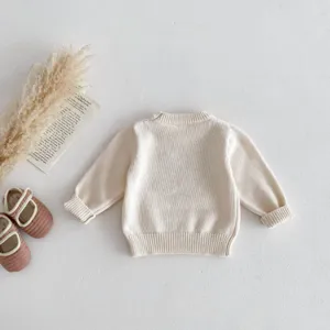 Details view of cute beige baby knit sweater back design with soft cotton fabric for infants.