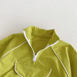 Primer plano del cuello de chaqueta verde para niños con ribete y cremallera blancos.