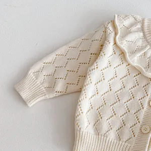 Infant knit cardigan sweater detail, hollow-out diamond pattern, elegant ruffle collar.