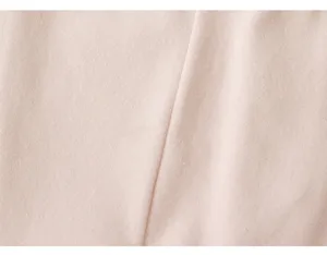 Primo piano dettagliato del morbido tessuto di cotone rosa e cuciture dei leggings da neonato.