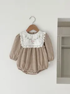 Detailed view of baby plaid romper with cute embroidered lace collar and long sleeves.
