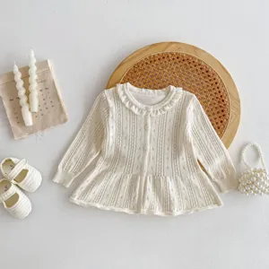 Detailed view of baby knitted cardigan, soft hollow-out cotton knitwear, sweet top.
