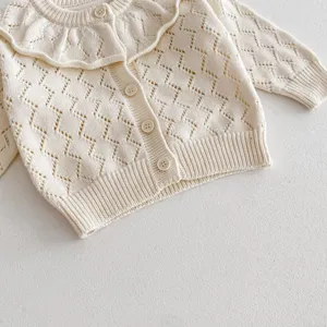 Detailed view of the baby knitted cardigan featuring a delicate hollow pattern and big ruffled collar.