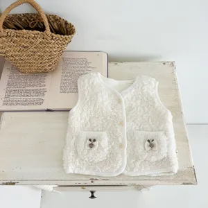 Detail shot of white baby lamb fleece vest, showing cute pocket buttons and fluffy fabric.