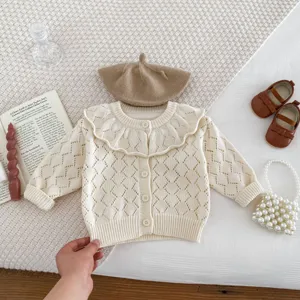 Detailed view of baby girl knit cardigan with hollow pattern and ruffled collar in set.