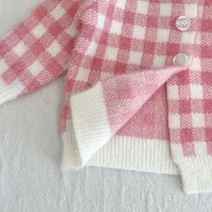 Gilet cardigan bebe carreaux rose blanc gros plan, detail de tissu pelucheux doux.