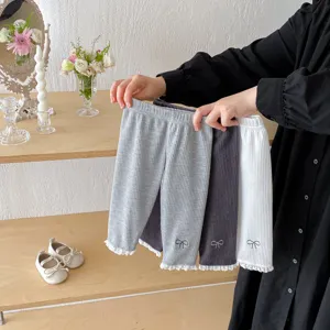 Infant ribbed leggings detail, featuring cute bow embroidery and delicate lace trim.