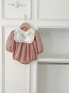 Detailed view of infant baby girl plaid romper with sweet embroidered collar and long sleeves.