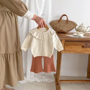 Infant baby knit cardigan and flare trousers set with cute ruffles, detail view.