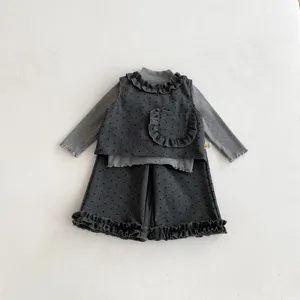Detailed view of toddler girls grey polka dot ruffle three-piece outfit set, close-up.